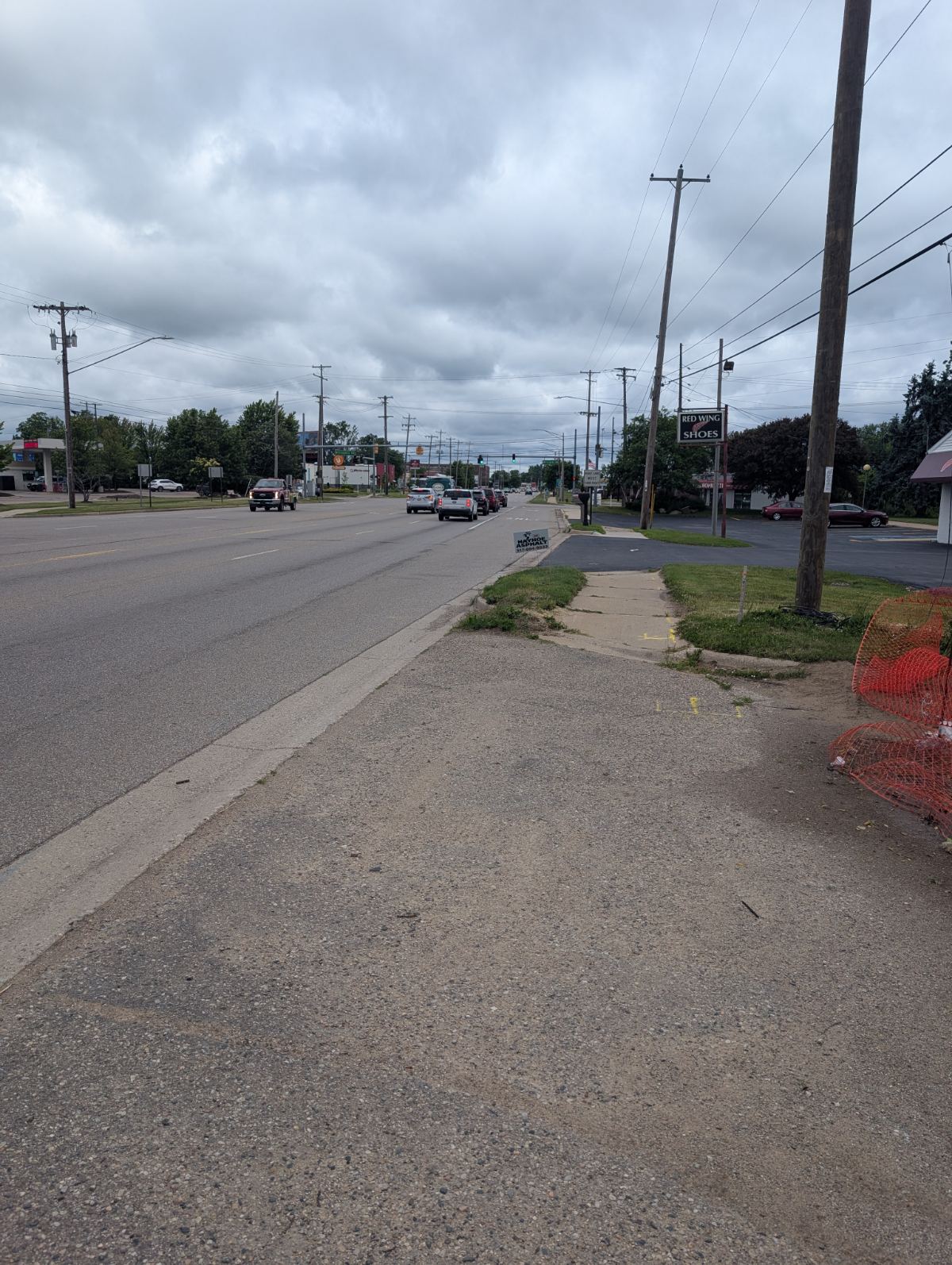 A wide multi-lane road in Lansing with power lines and no pedestrians