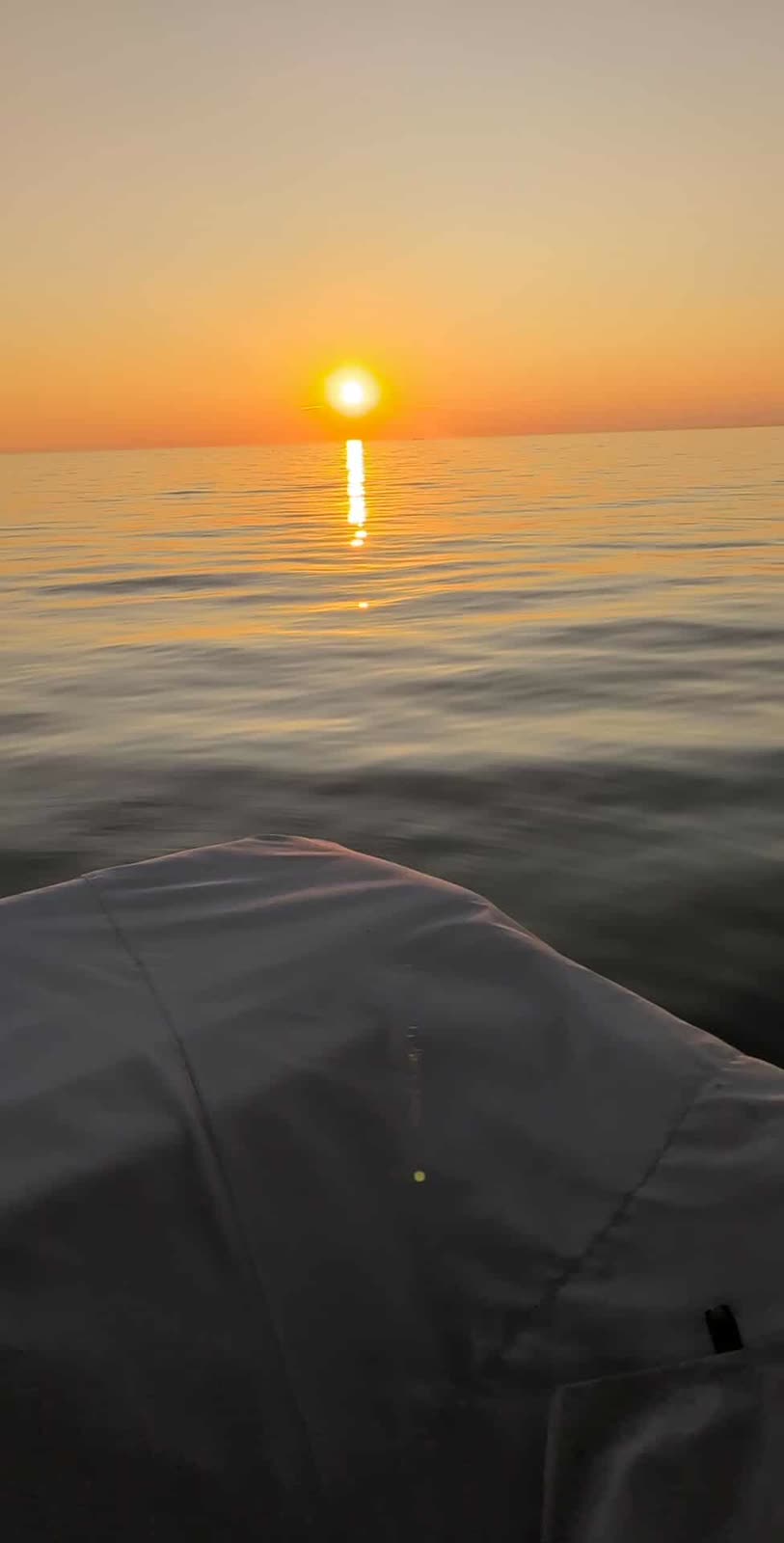 Orange and gold sunset over calm Lake Michigan water